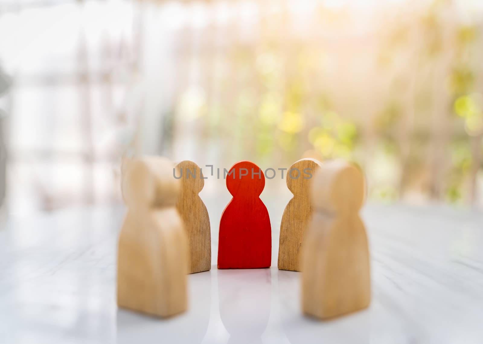 Figure in human resource management concept. The group of wooden puppets is a circular. A red wooden figure like an dominant in a group with blur bokeh background
