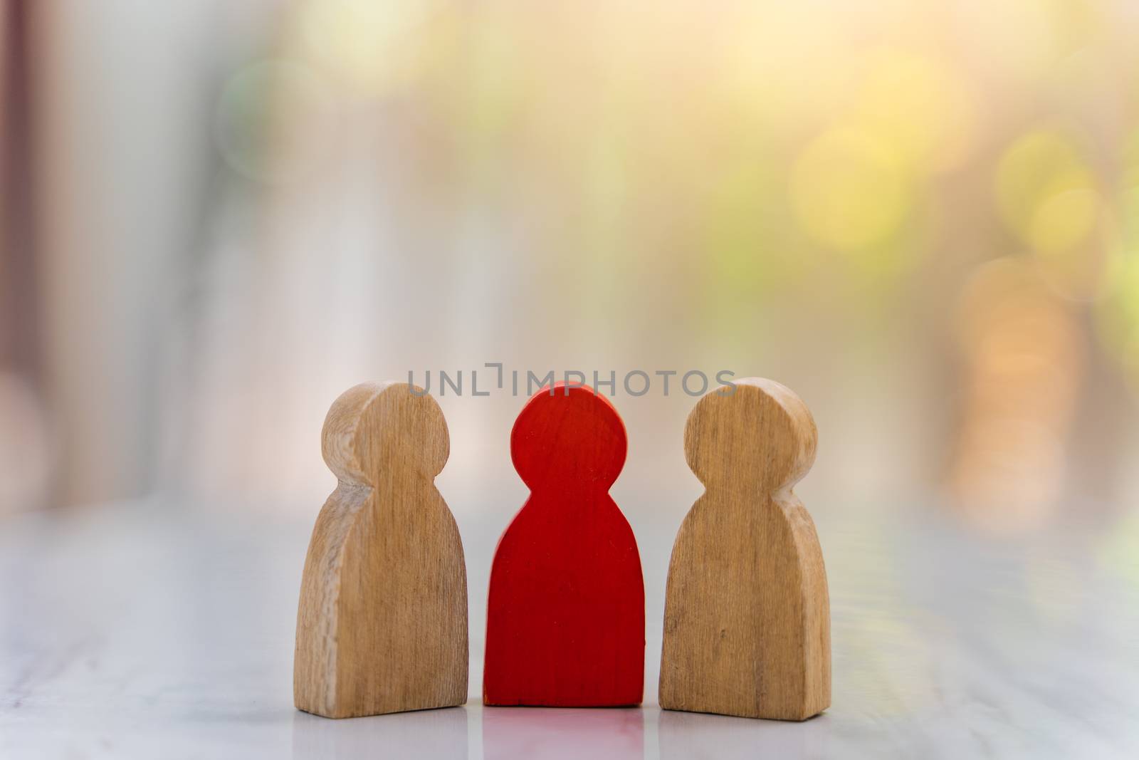 Figure in human resource management concept. The group of wooden puppets A red wooden figure like an dominant in a group with blur bokeh background
