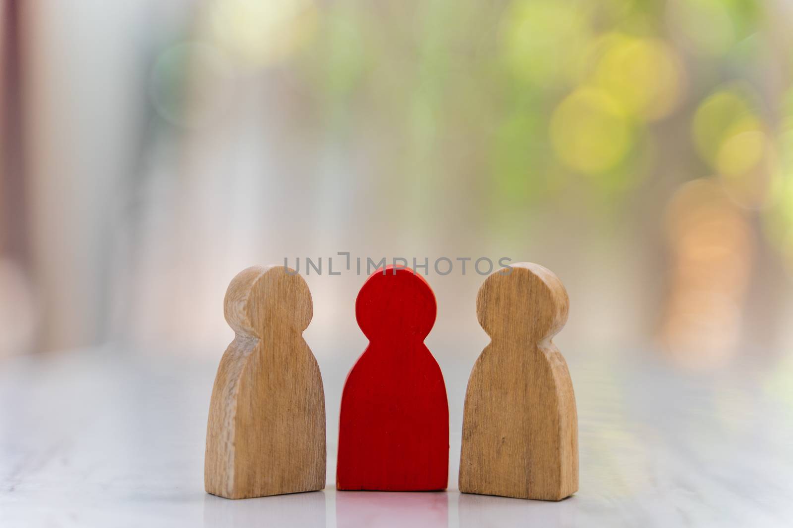 Figure in human resource management concept. The group of wooden puppets A red wooden figure like an dominant in a group with blur bokeh background
