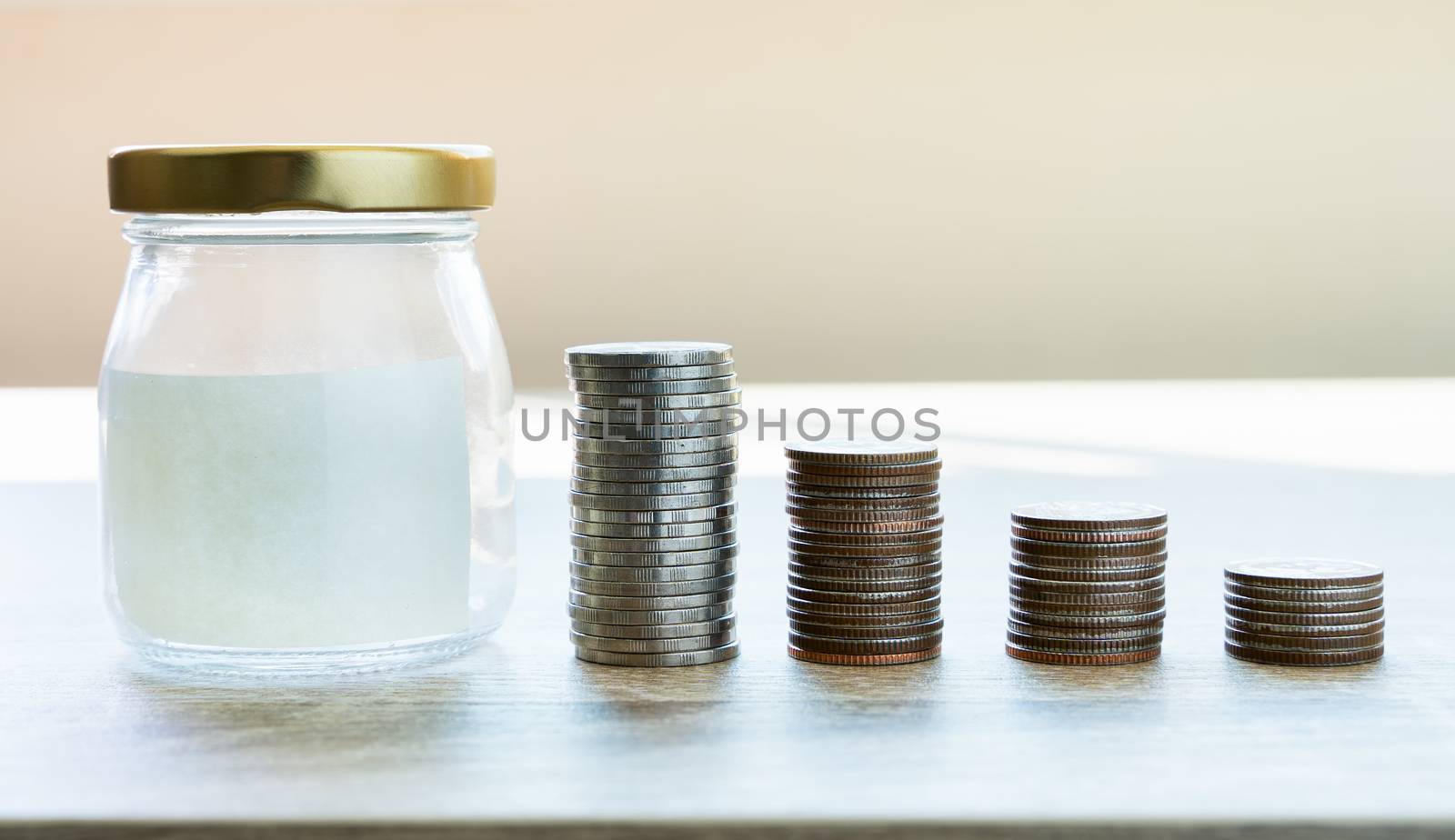Money savings concepts. Put coins in glass bottles with paper la by Boophuket