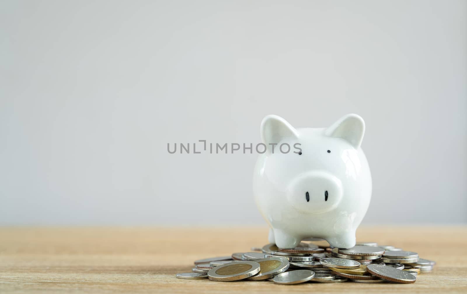 Money savings concepts Piggy bank symbol of saving with coins on wooden table with blur background and copy space