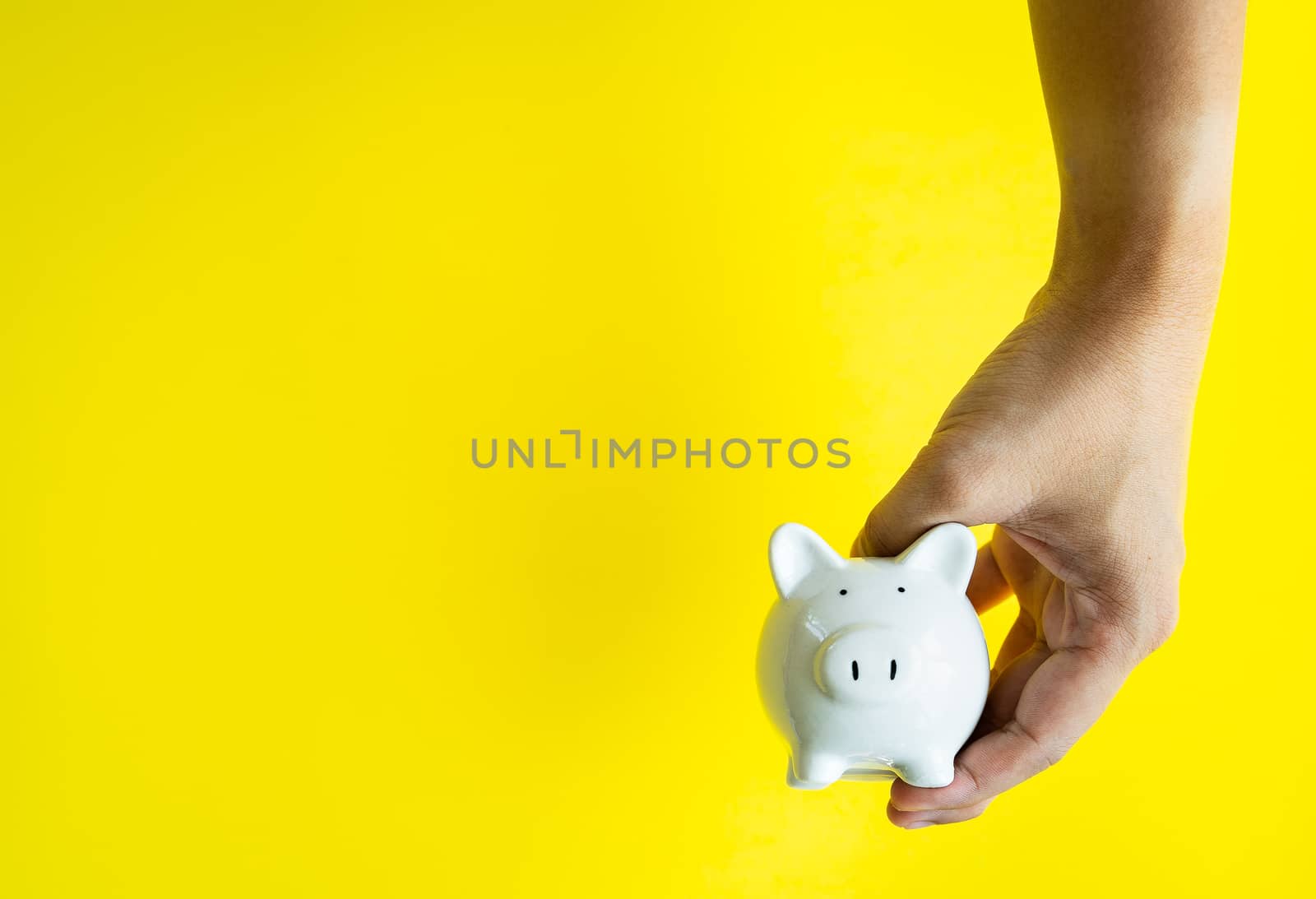 Money savings concepts. The piggy bank in hand is giving for sav by Boophuket
