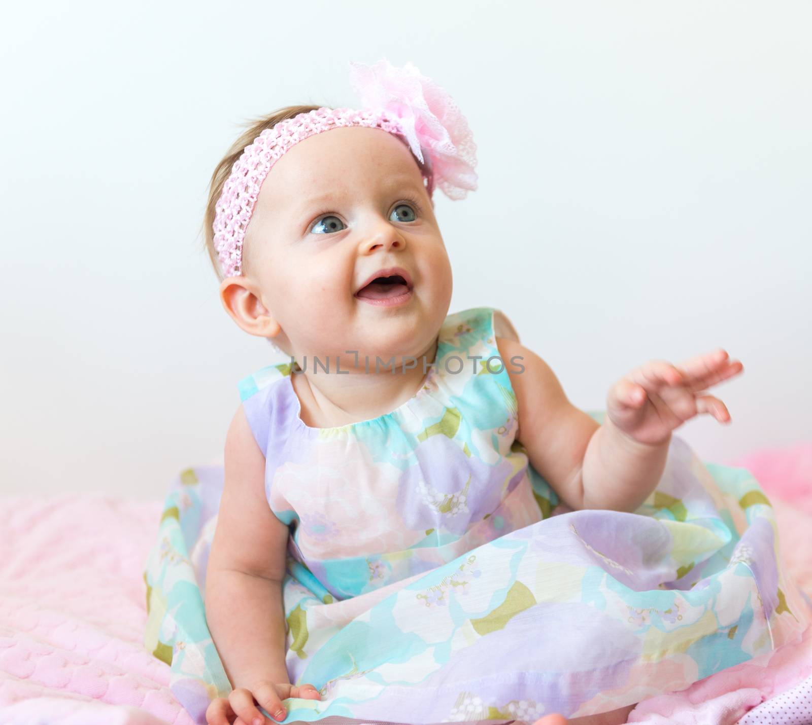 Cute 6 months old baby girl wearing beauty dress on light background