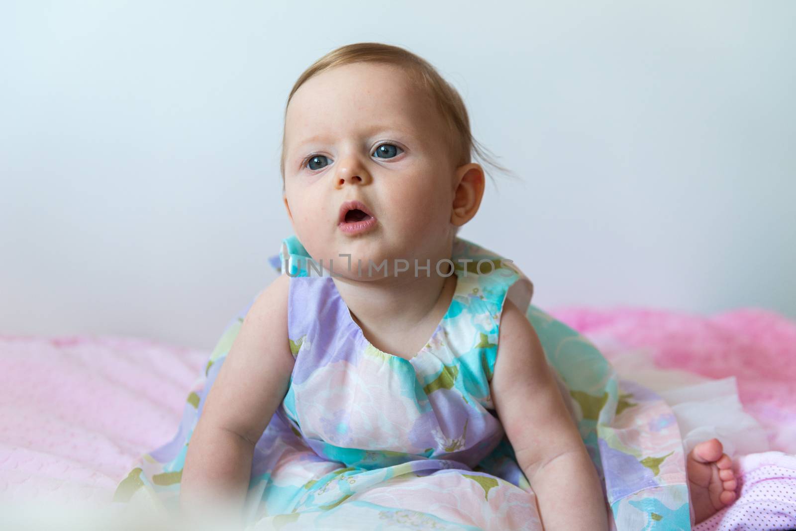 Cute 6 months old baby girl wearing beauty dress on light background