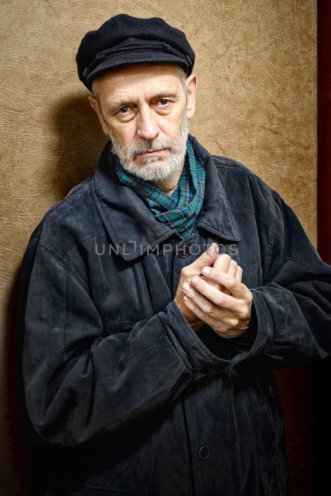 Portrait of a mature man with a white beard and a cap on the head. He could be a sailor, a worker, a docker, or even a gangster or a thug. He has a penetrating gaze.