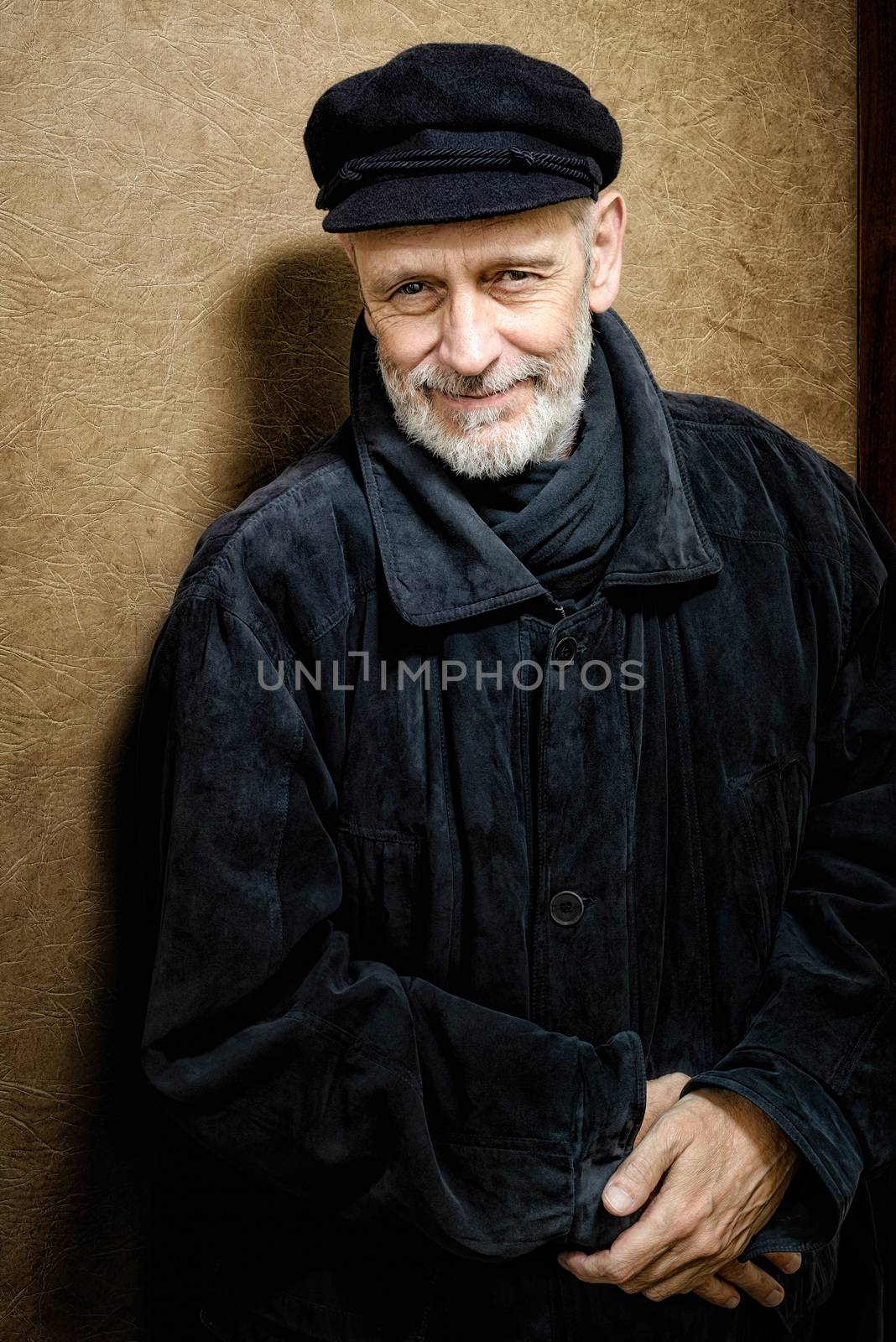 Portrait of a mature man with a white beard and a cap on the head. He could be a sailor, a worker, a docker, or even a gangster or a thug. He has a penetrating gaze.