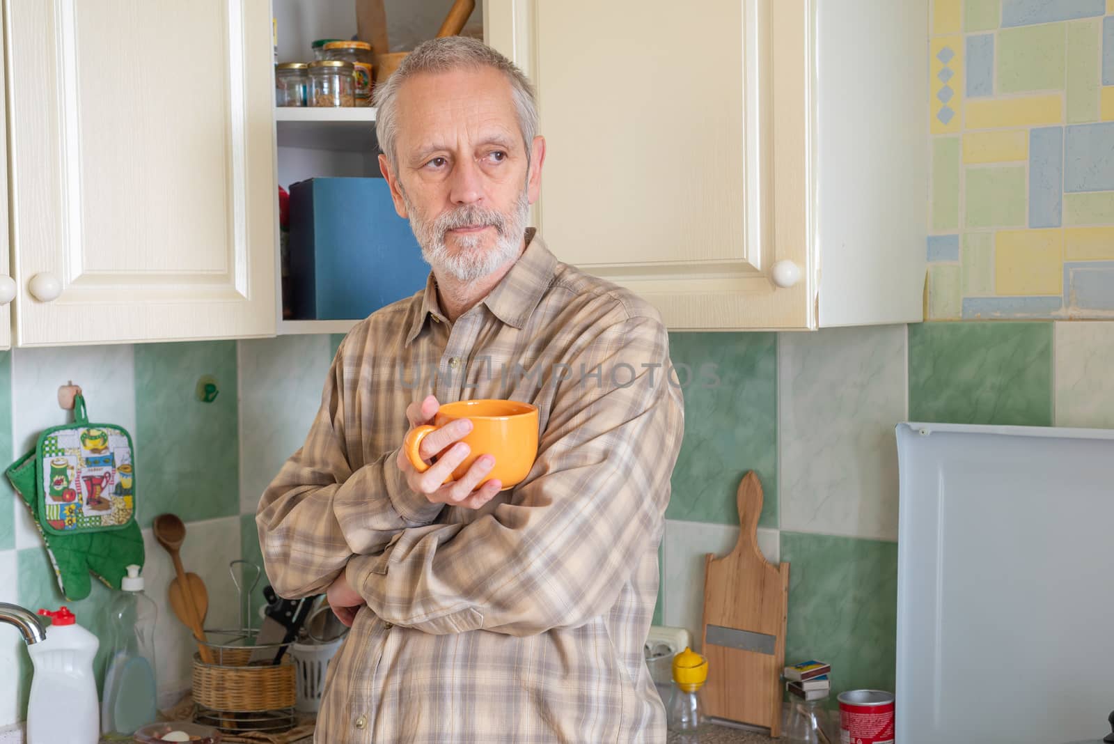 Mature man drinking his coffee in kitchen by MaxalTamor