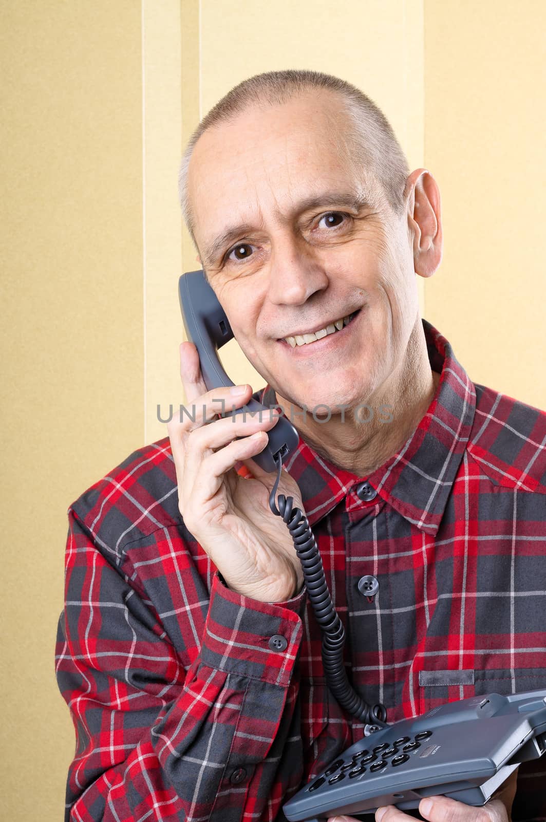 Cheerful man smiling and speaking on phone