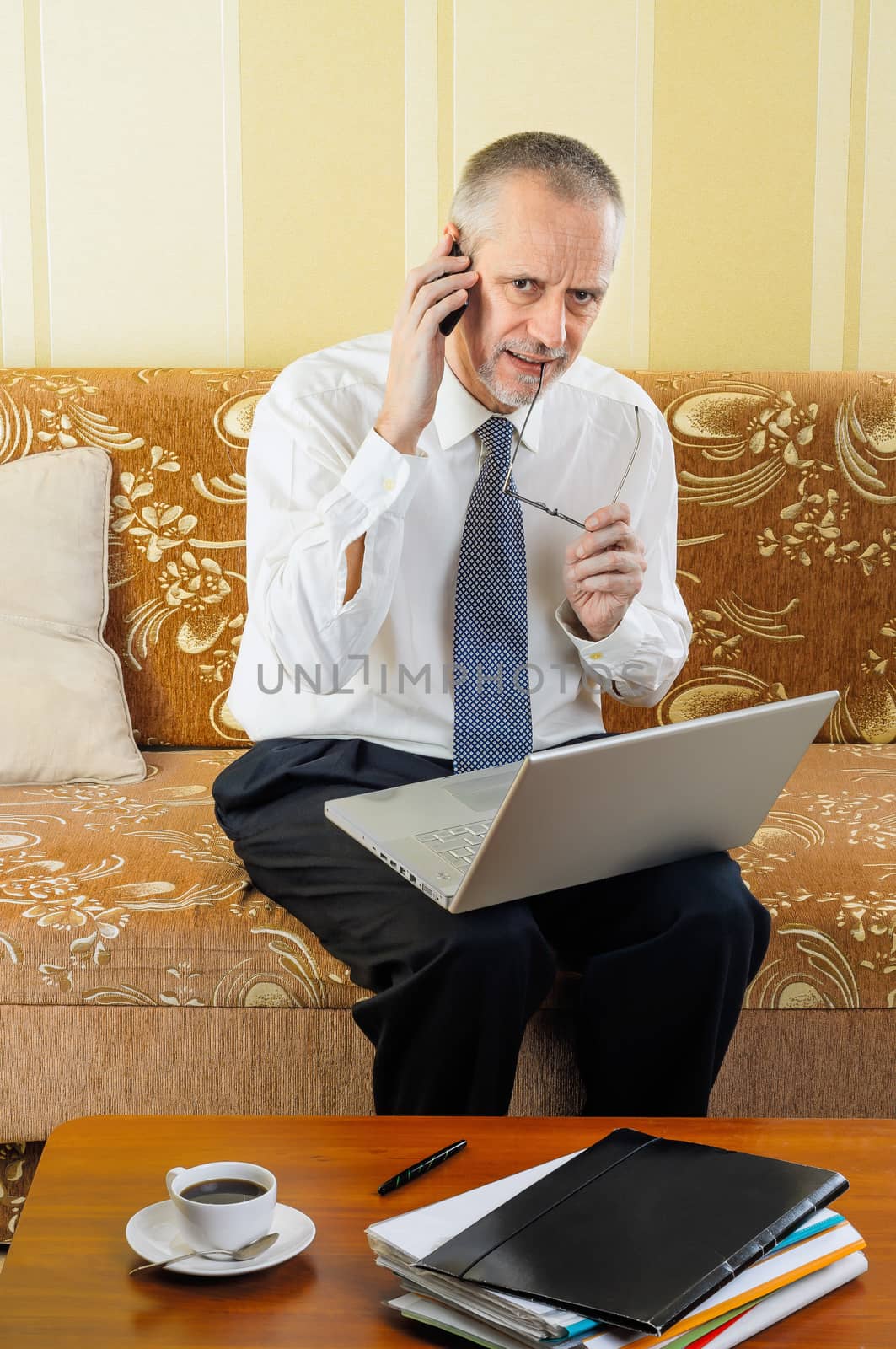 Senior Businessman Working with Computer and Smartphone by MaxalTamor