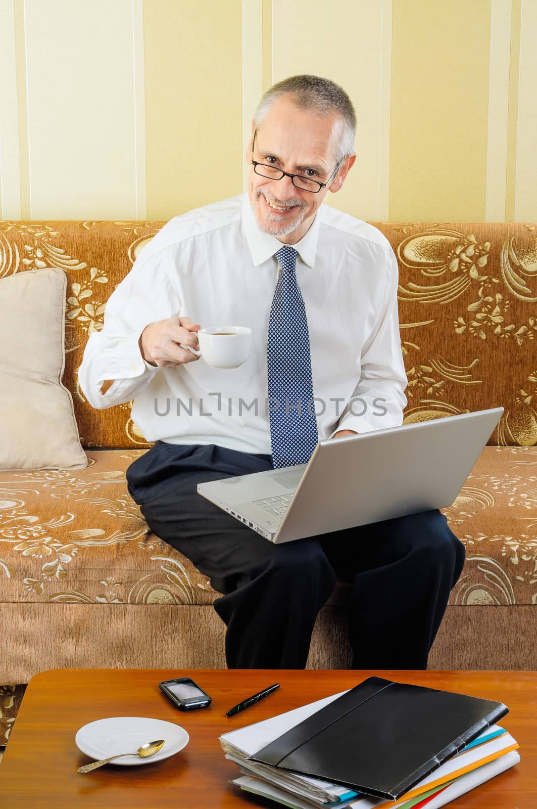 Senior Businessman with Computer Drinking Coffee by MaxalTamor