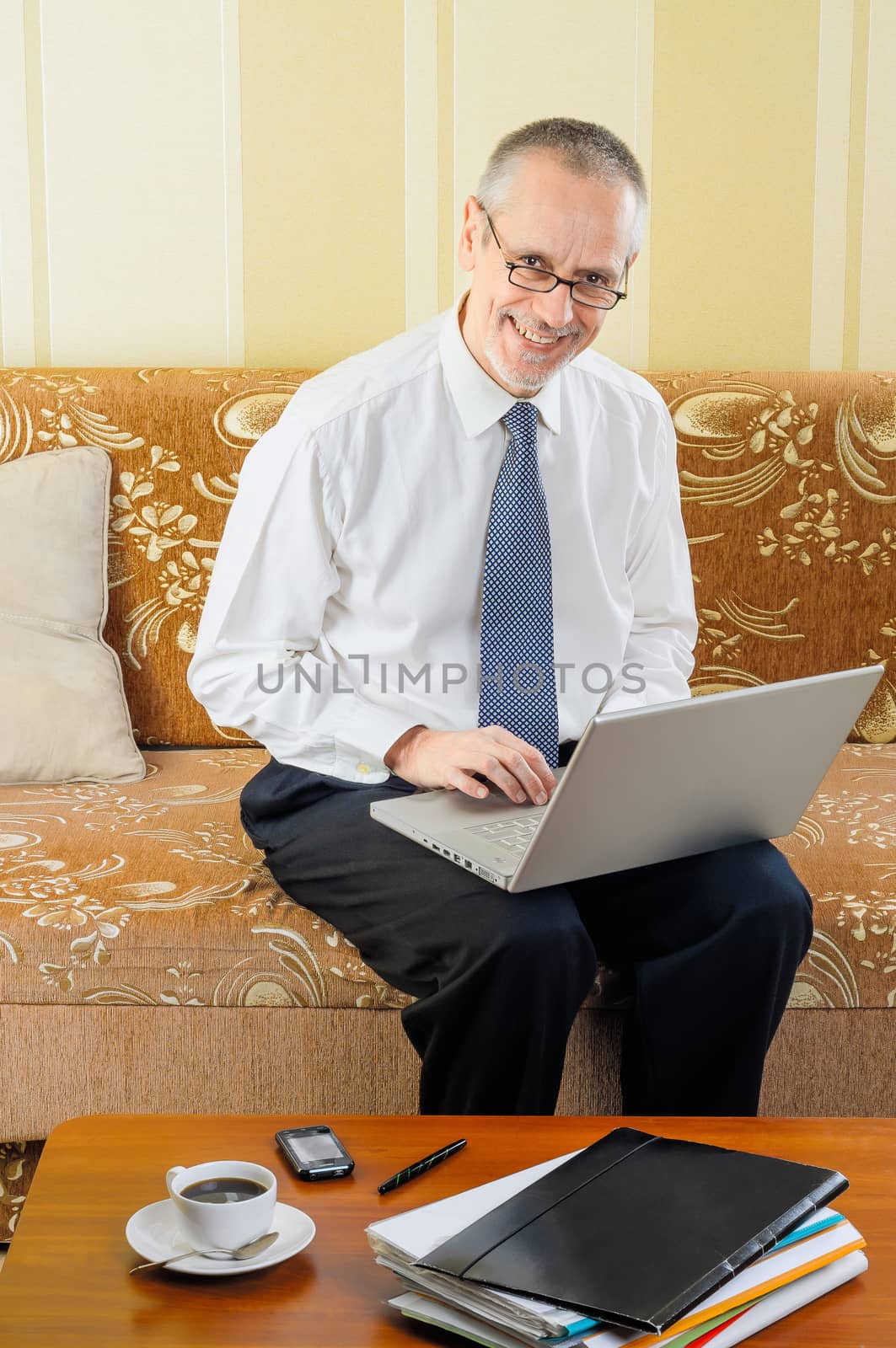 Friendly Senior Businessman with Computer by MaxalTamor