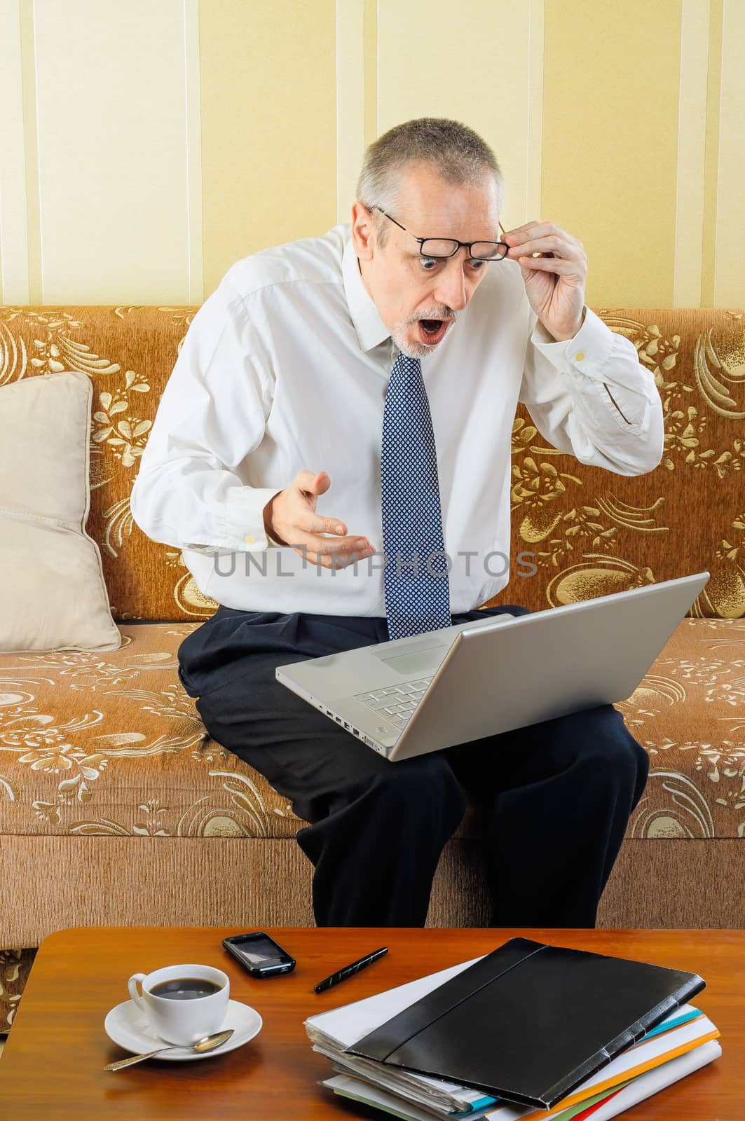 Surprised Senior Businessman with Computer by MaxalTamor