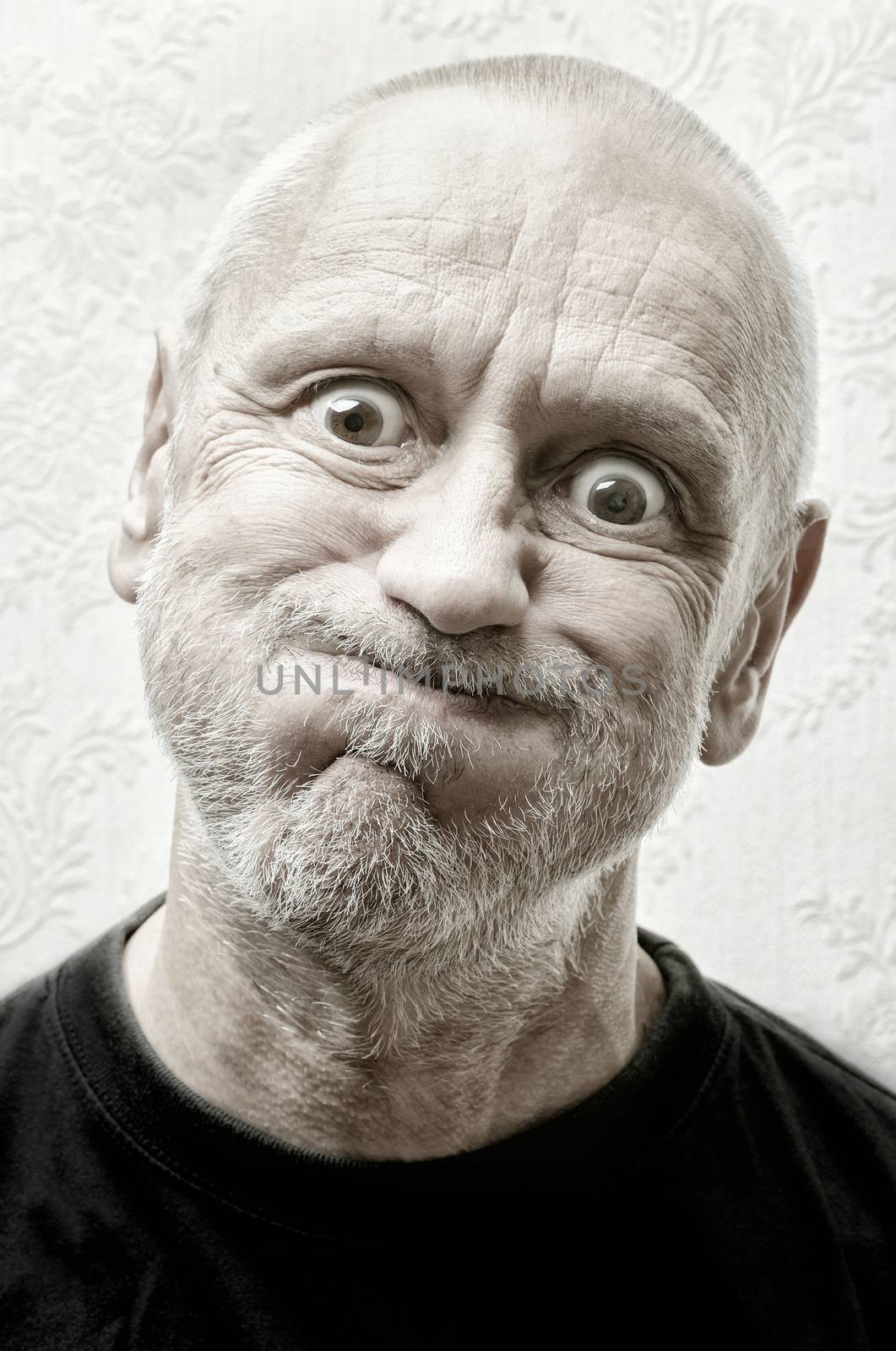 Black and white portrait of a funny and crazy caucasian man making faces with eyes round like balls and puffy cheeks