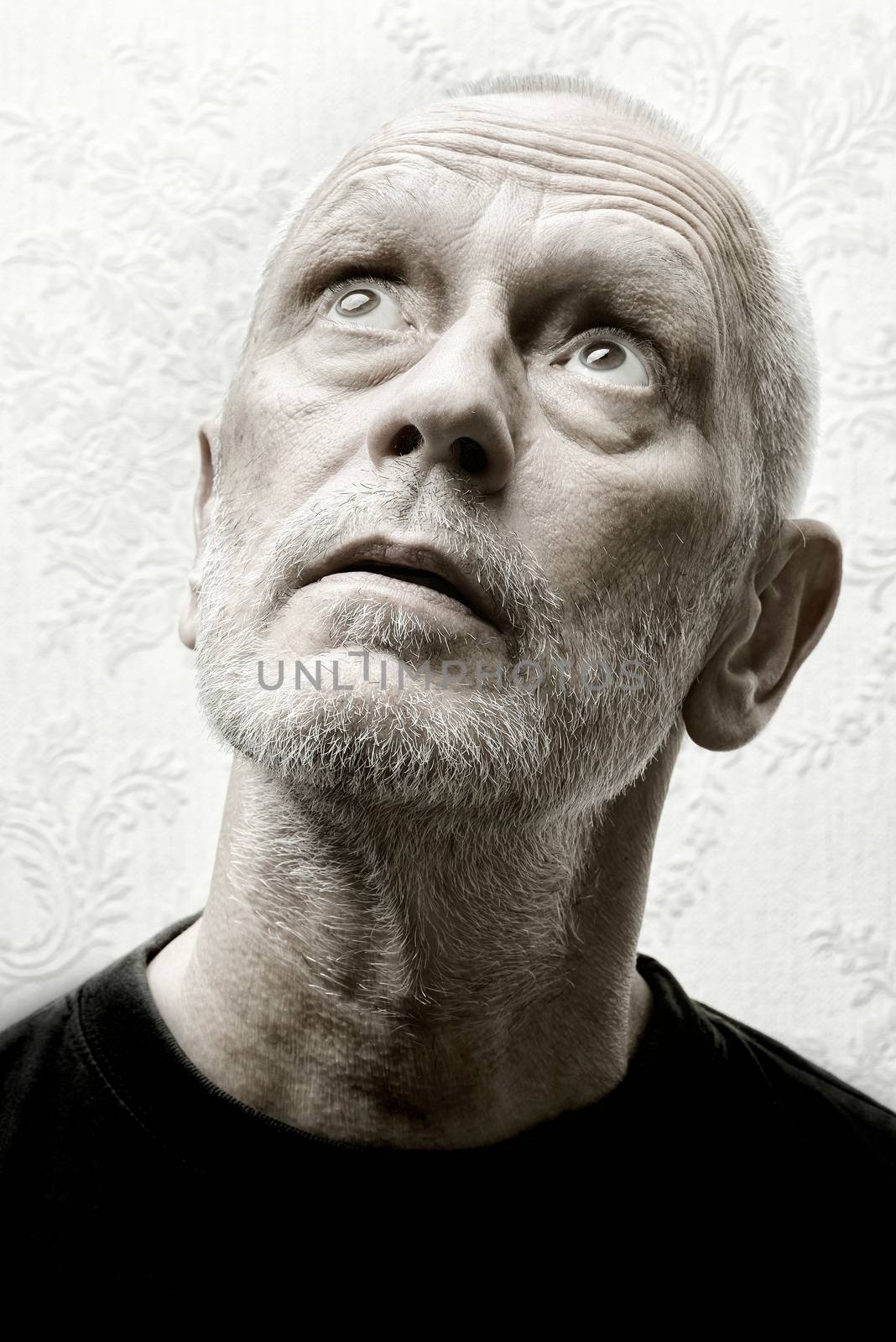 Black and white portrait of an agape and inquisitive caucasian adult man with eyes looking up