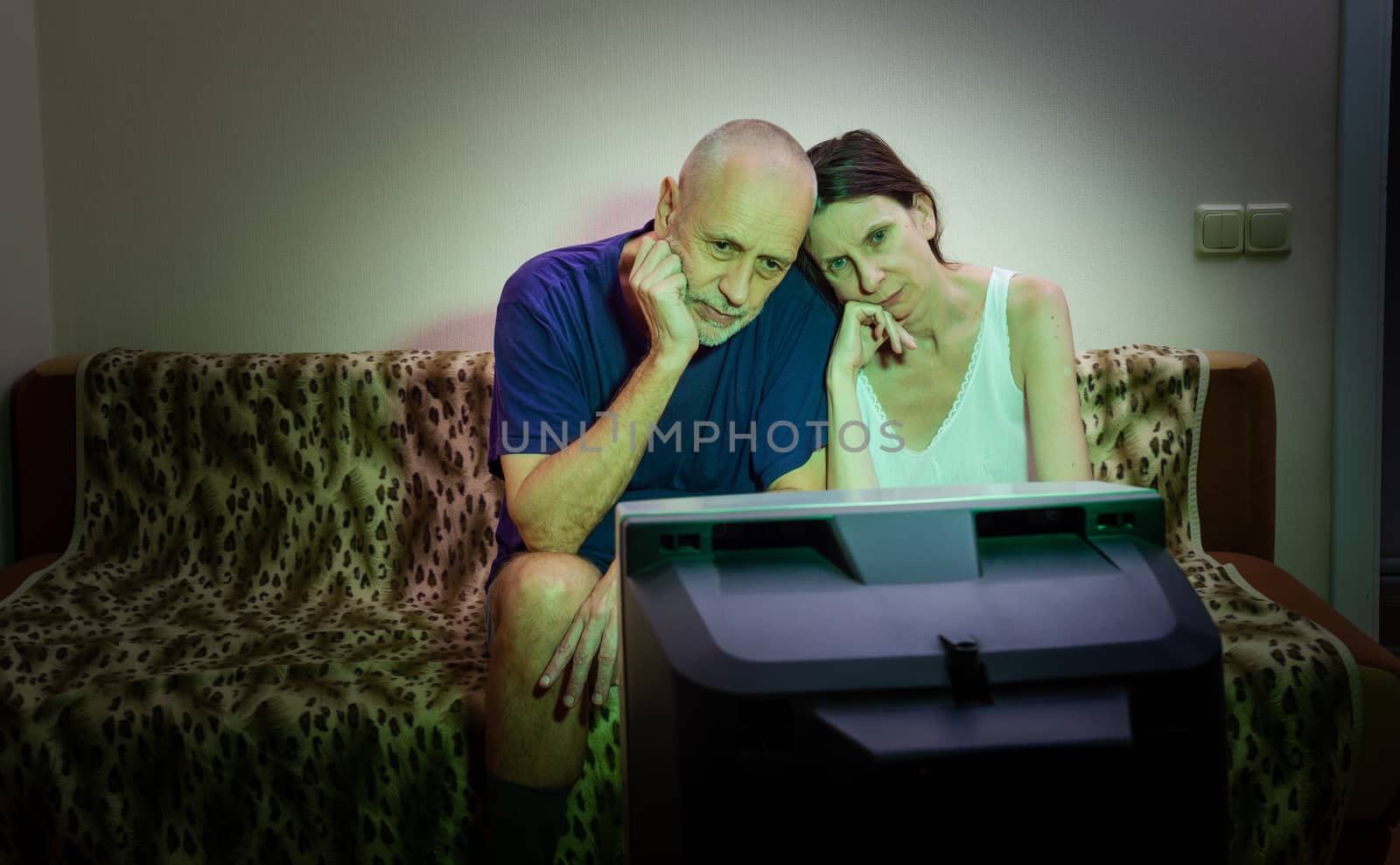 A couple of adult lovers, sitting on a couch watch movie on tele by MaxalTamor