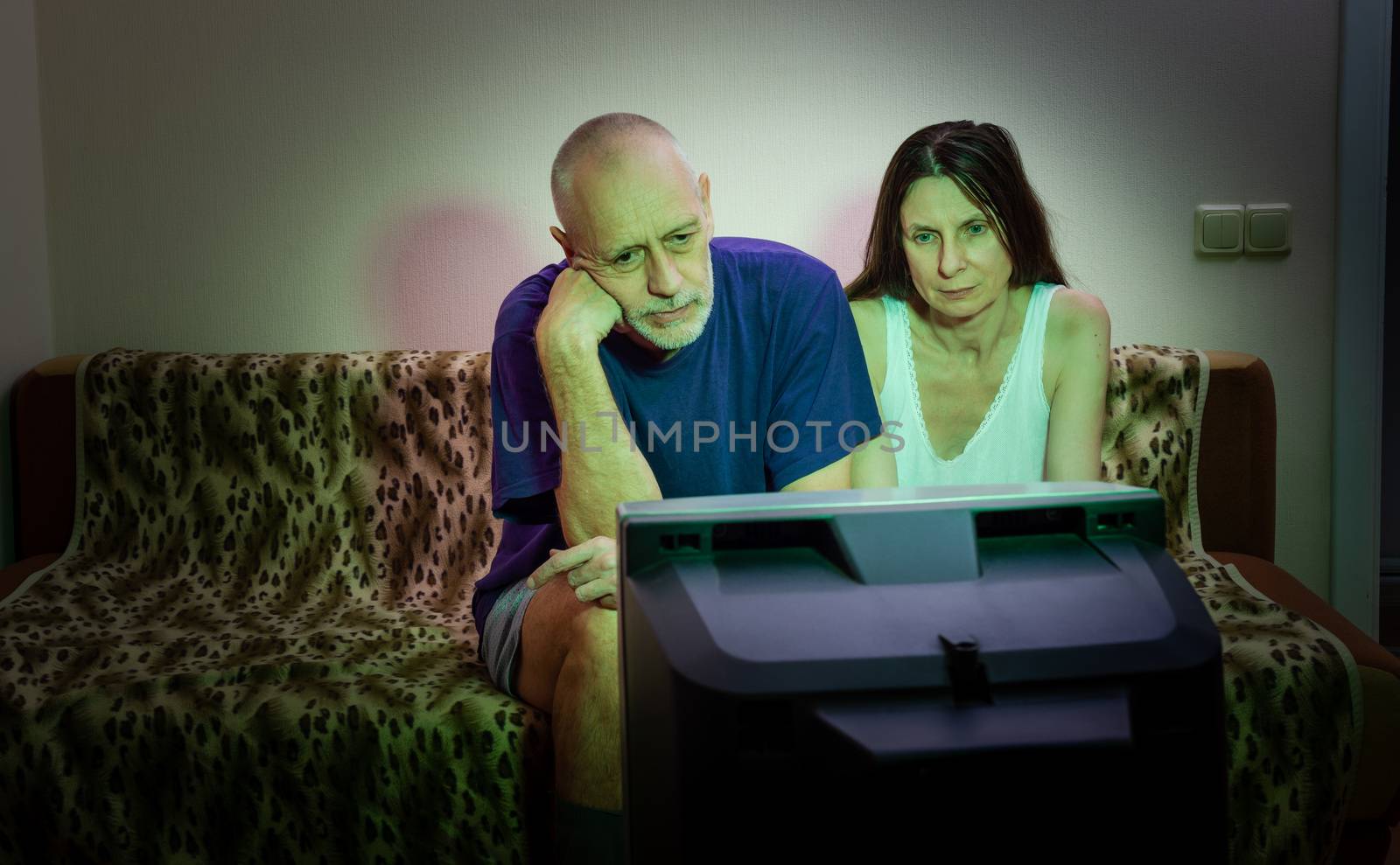 A couple of adult lovers, sitting on a couch watch movie on tele by MaxalTamor