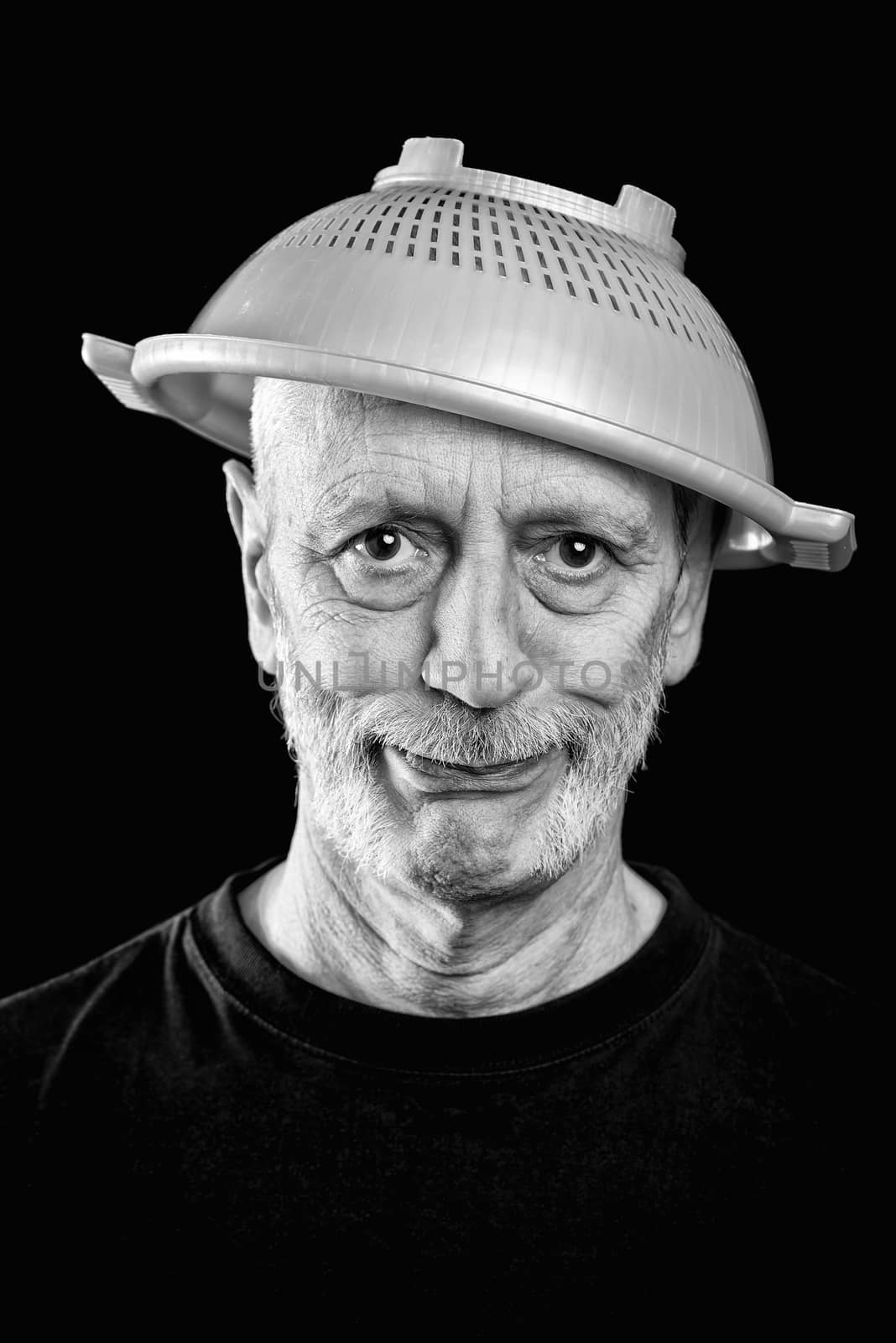 Dramatic black and white Portrait of a mad man with a plastic strainer on the head