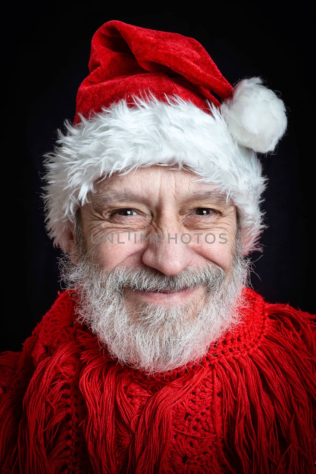 Portrait of an adult man with white beard disguised in Santa Claus for the Christmas Holiday