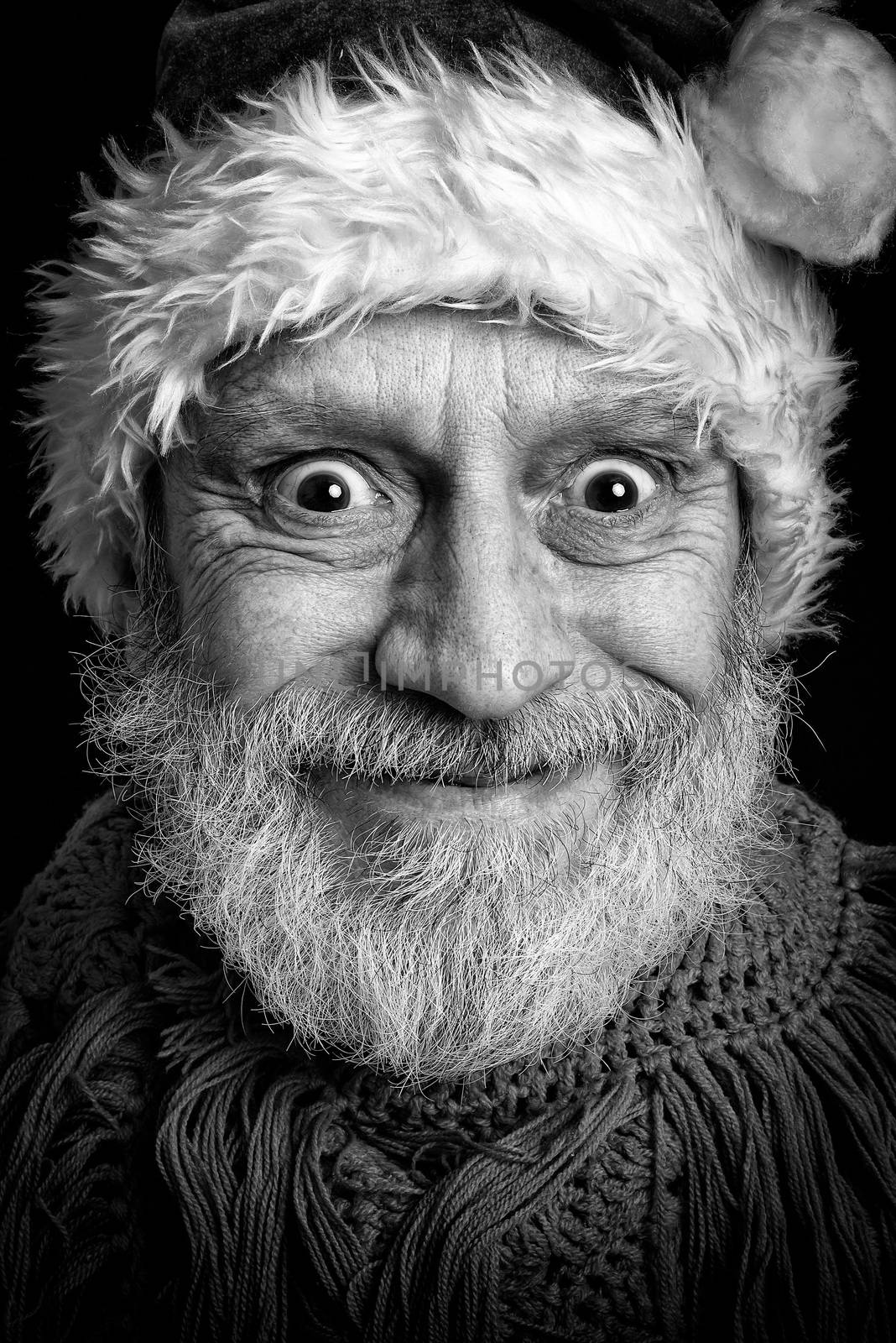 Black and white portrait of an adult man with white beard disguised in Santa Claus for the Christmas Holiday