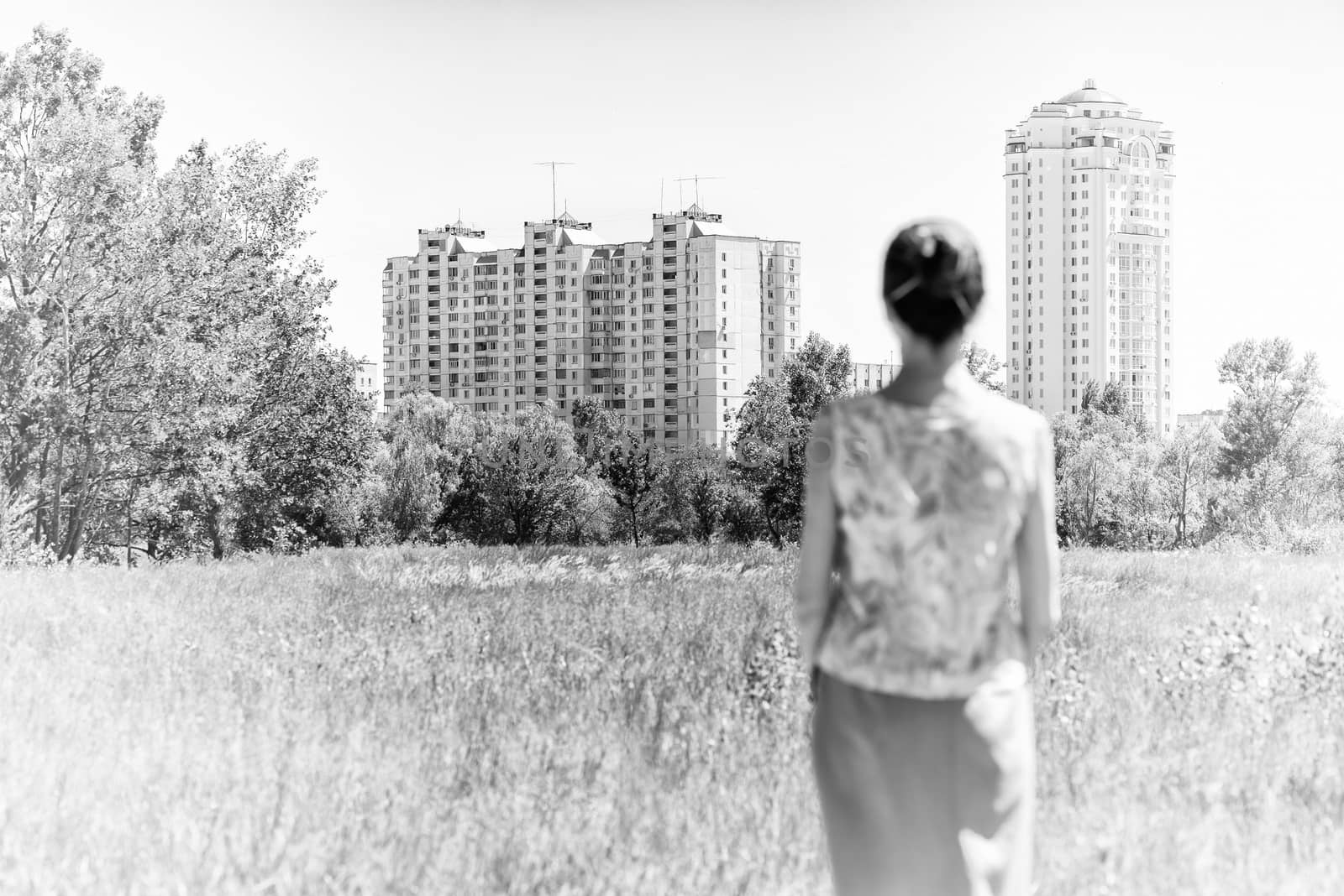 Woman looking at modern residential buildings by MaxalTamor