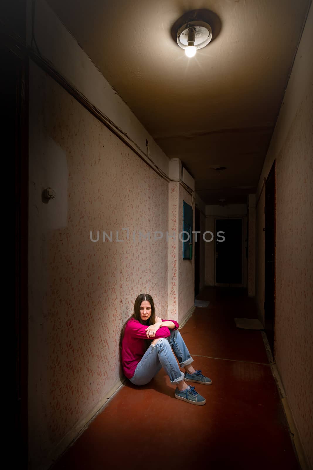 Sad and desperate woman sits in a dark corridor by MaxalTamor