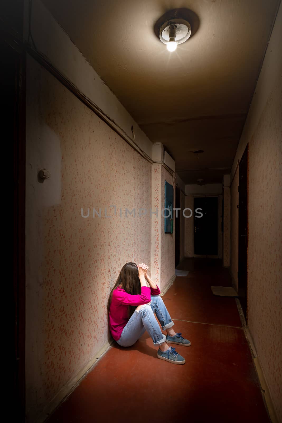 Sad and desperate woman sits in a dark corridor by MaxalTamor