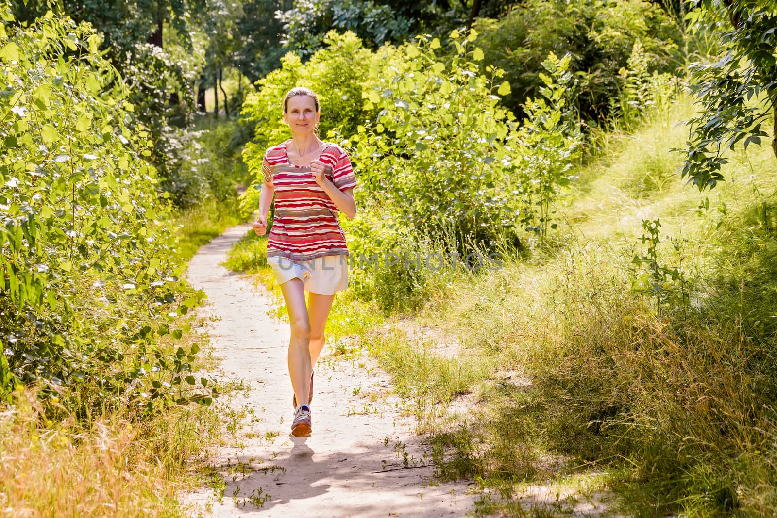 Senior Woman Running in the Forest by MaxalTamor