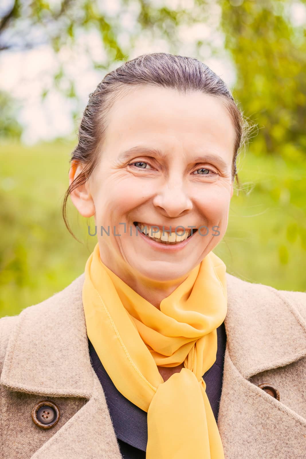 Portrait of a mature smiling businesswoman with a coat and a yellow scarf