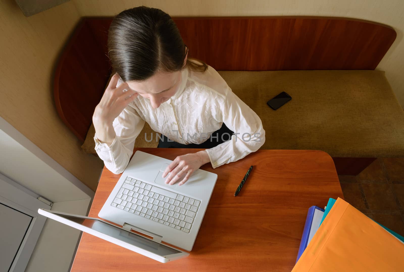 An elegant business woman is using a laptop computer. She is satisfied of her work.
