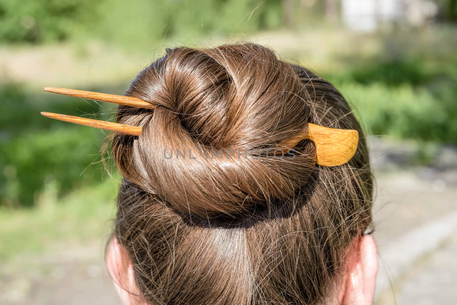 Detail of a chignon with a wooden hairpin to keep the hair attached together