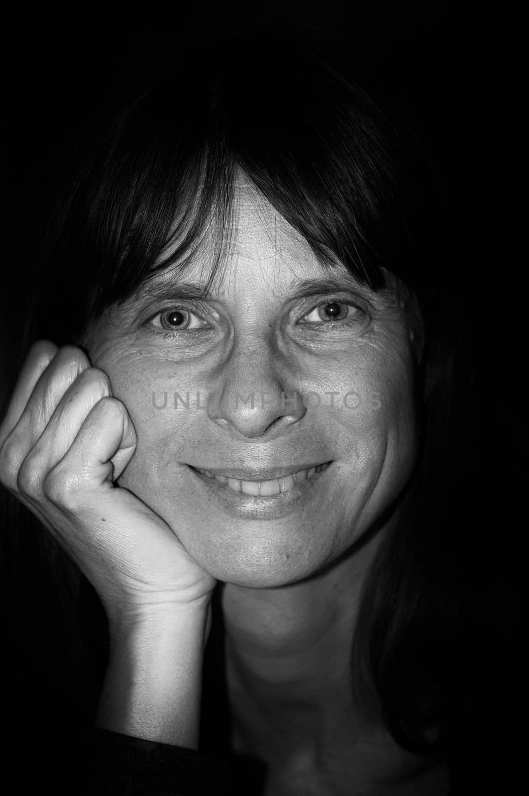 Black and white portrait of a happy adult woman with long hair is  smiling with a warm and positive expression