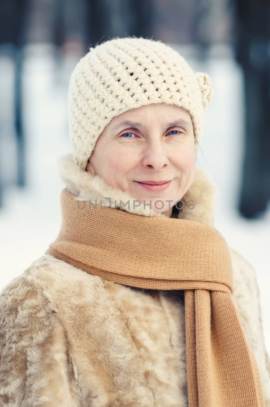 Portrait of a natural adult woman with a scarf and a a woolen hat, outdoor during winter
