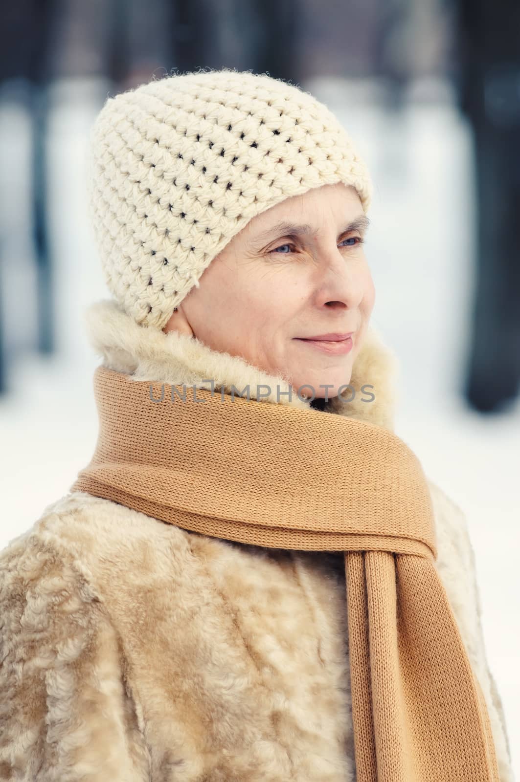 Portrait of a natural adult woman with a scarf and a a woolen hat, outdoor during winter