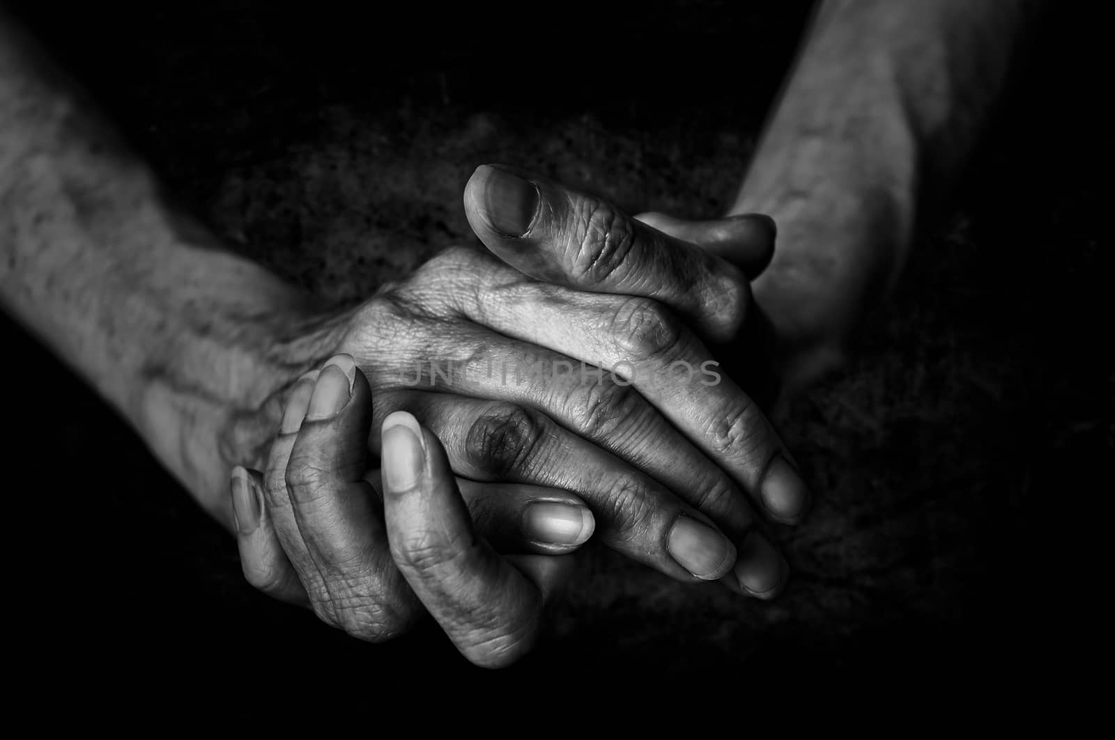 Black and White photo of senior woman hands on black background