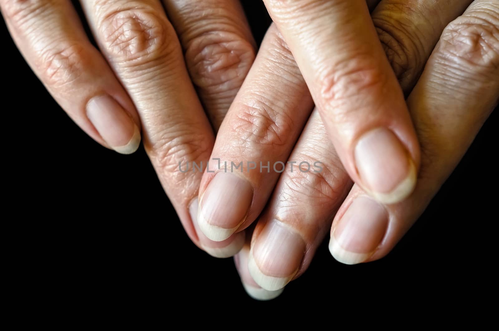 Nice senior woman's fingers on black background