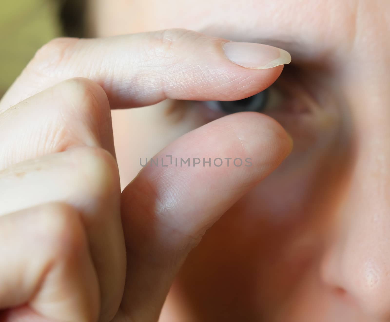 Fingers showing "something little" - Blurred face in the background