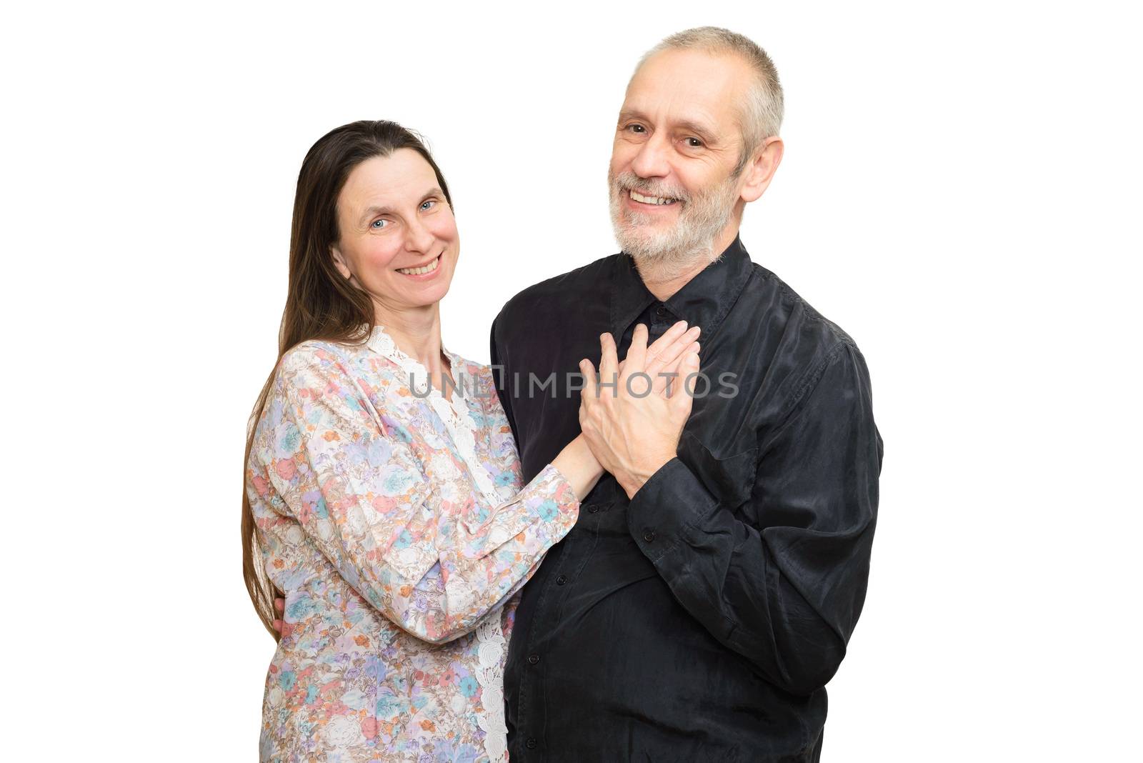 Happy mature man and woman with long hair smiling for S. Valentine's day or anniversary and putting the hands on the heart. Isolated on white background.