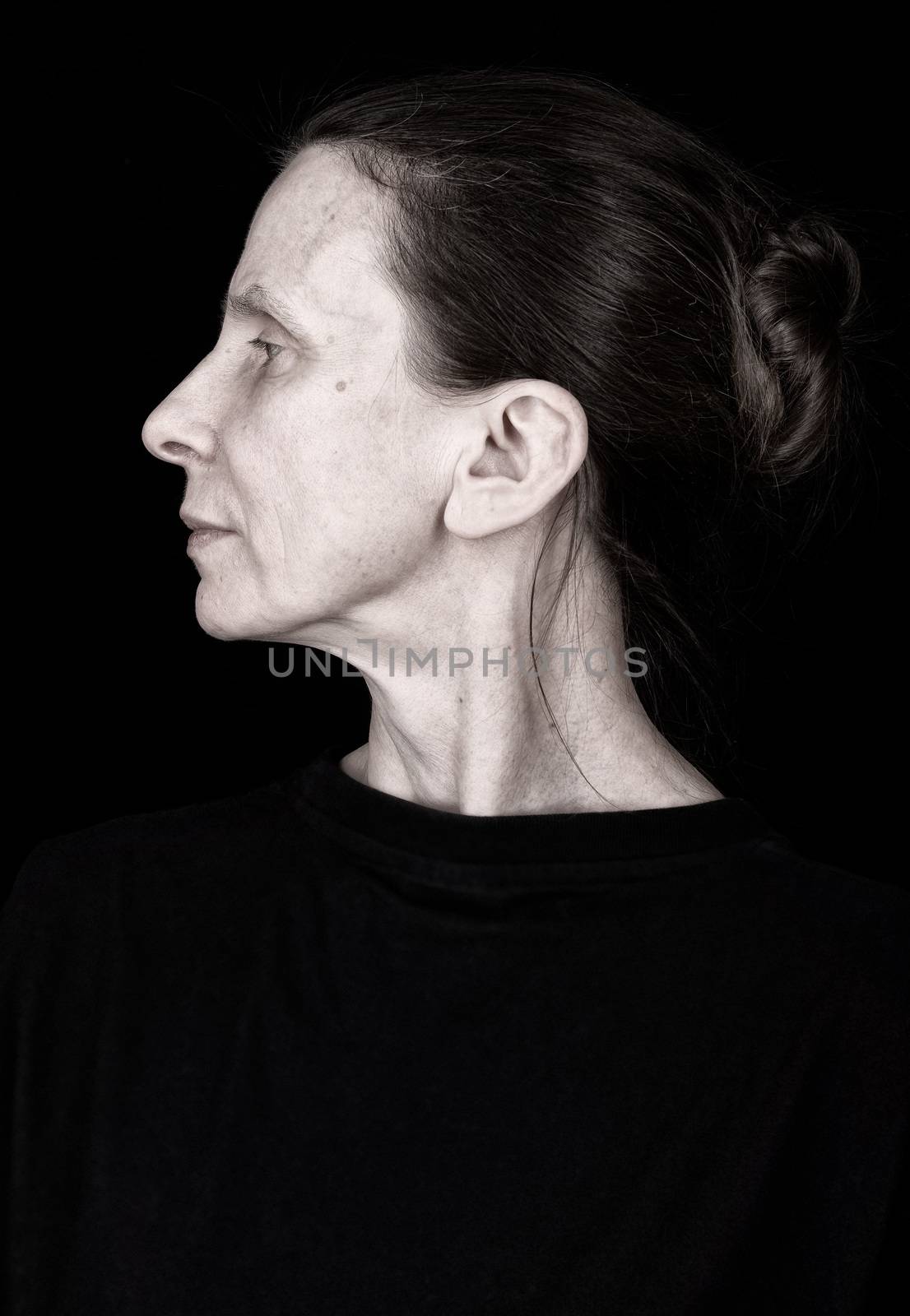 Left profile of a serious adult woman with a topknot