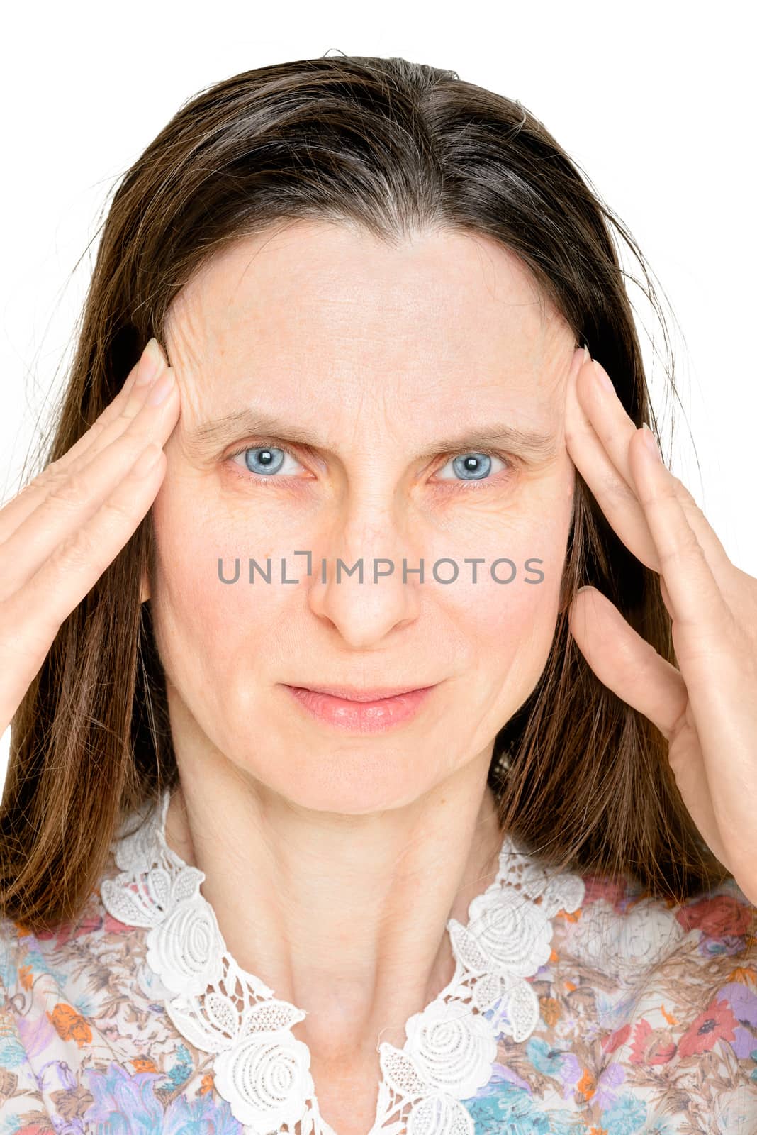 An adult woman puts her fingers on the temples because she suffers of headache