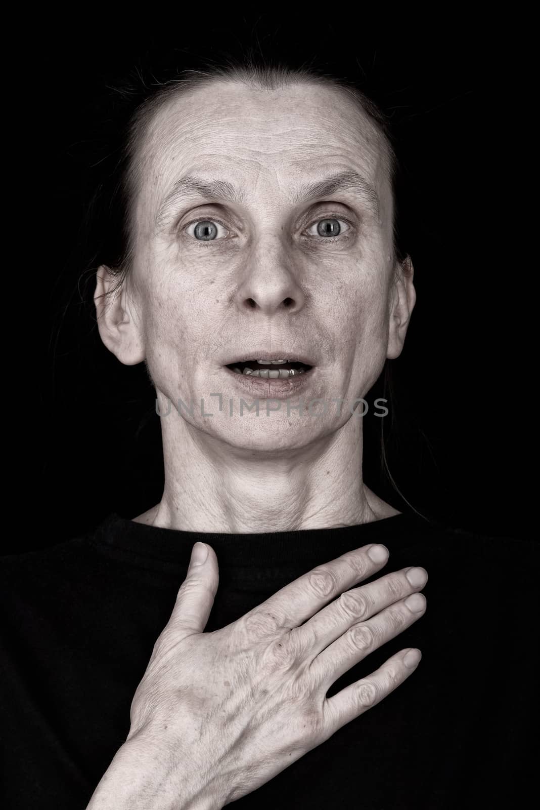 Portrait of a surprised adult woman speaking and putting the hand on her chest