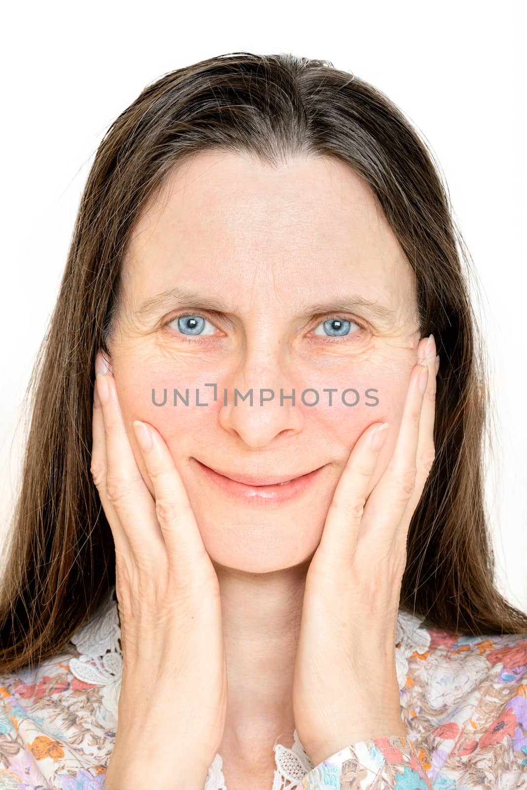 Portrait of a happy smiling mature woman, with the hands on her face