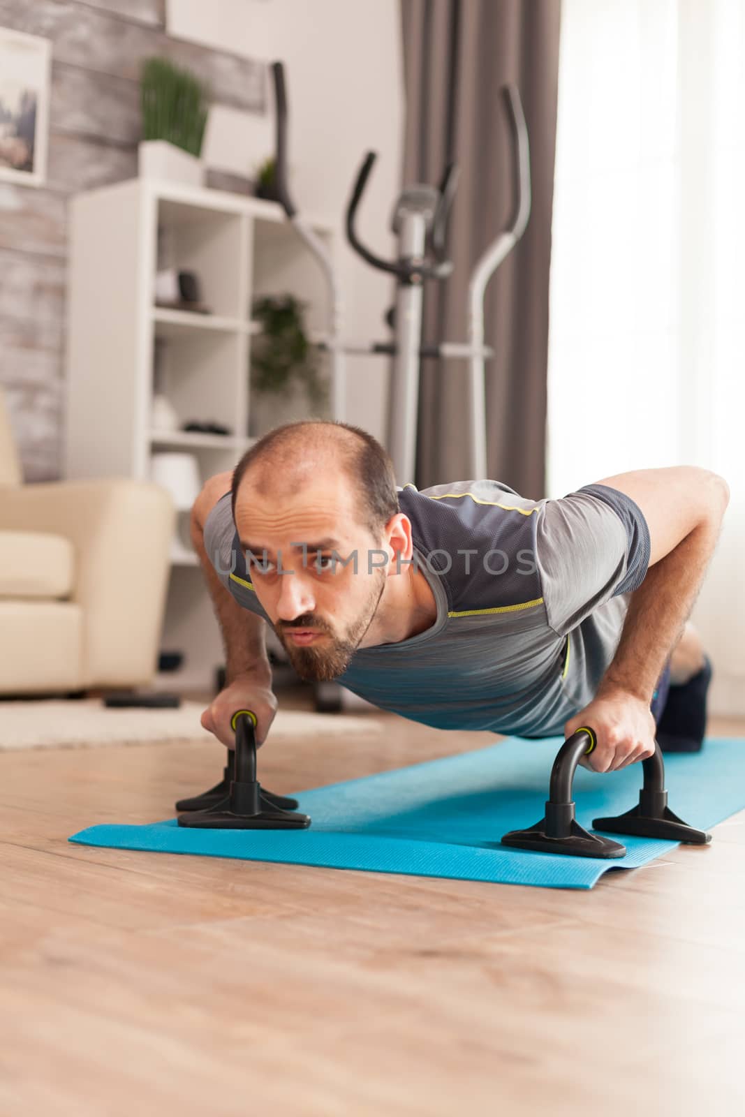 Strong man doing push ups on yoga mat during self isolation.