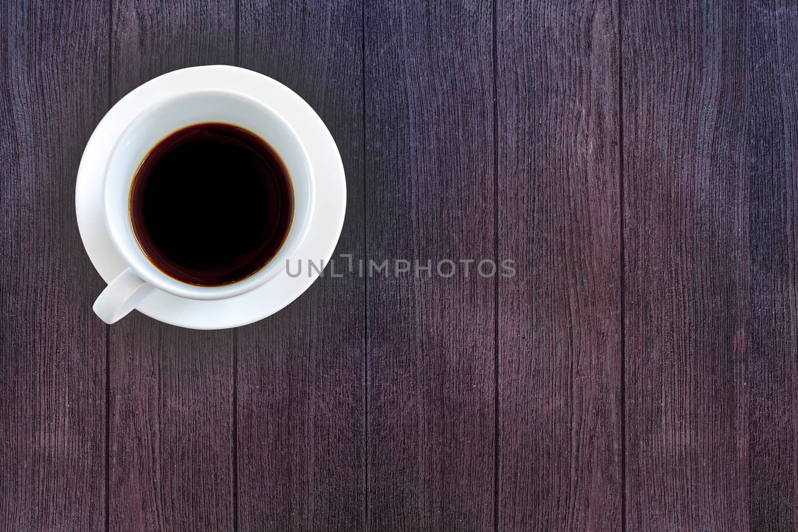 Top view White ceramic cup of black coffee on dark wooden background. Freshness in morning concept. Copy space for your text.