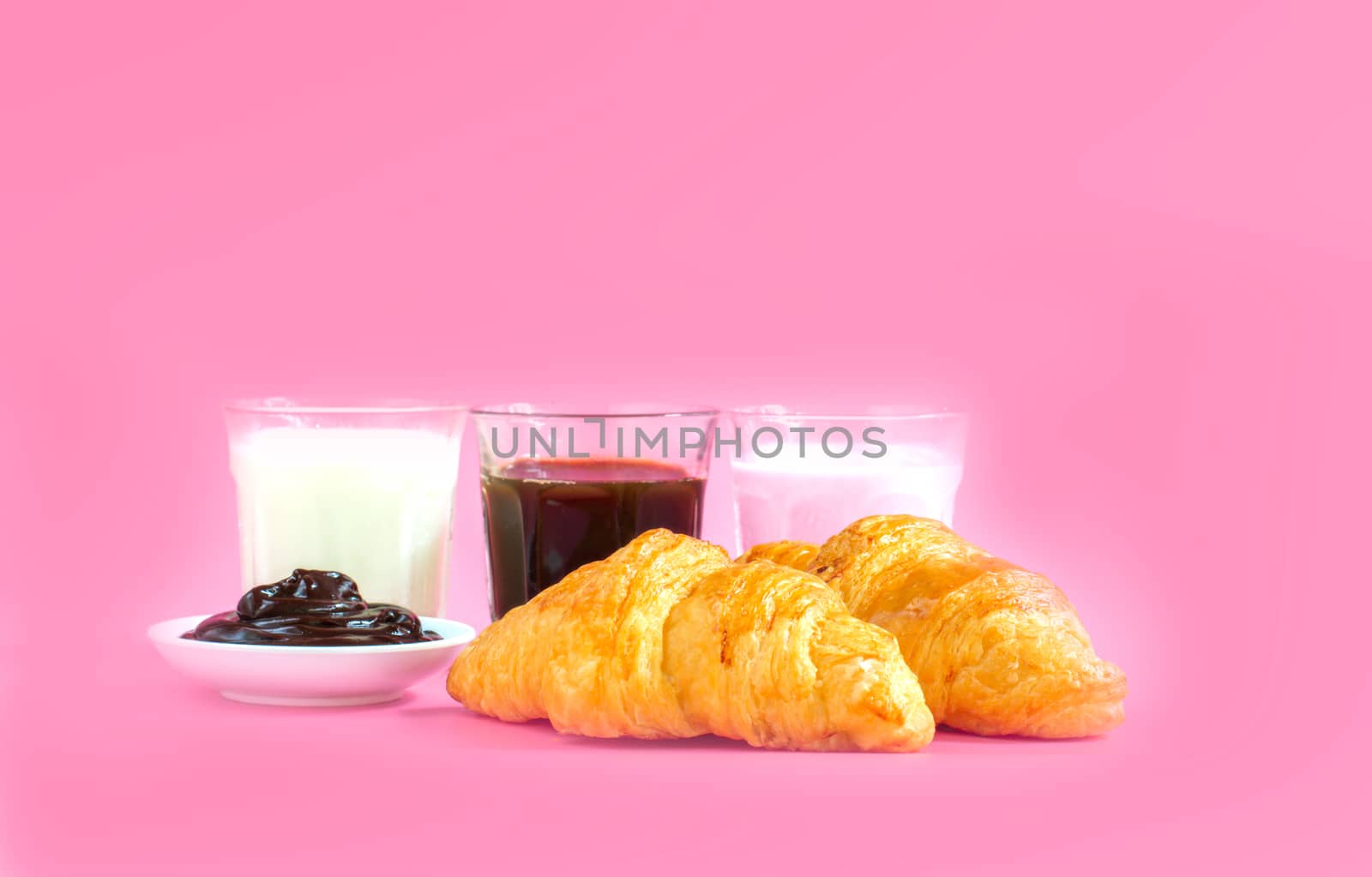 croissants served with glass of Fresh milk, coffee on pink background. Breakfast concept.