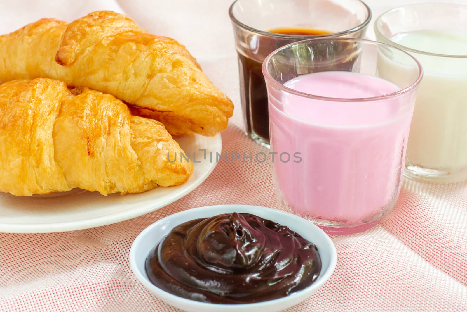 croissants served with glass of Fresh milk, coffee on pink background. Breakfast concept.