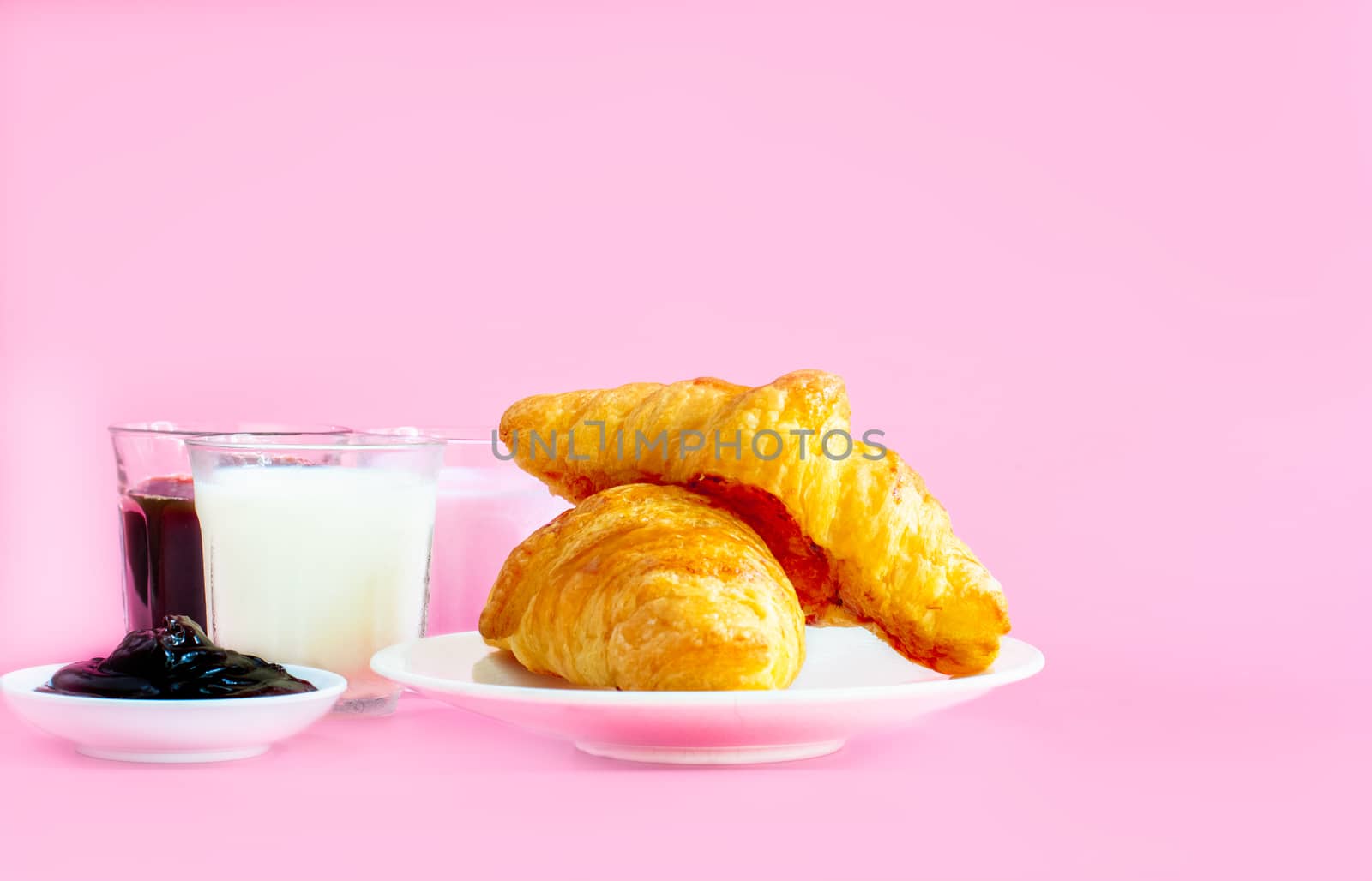 croissants served with glass of Fresh milk, coffee on pink background. Breakfast concept.