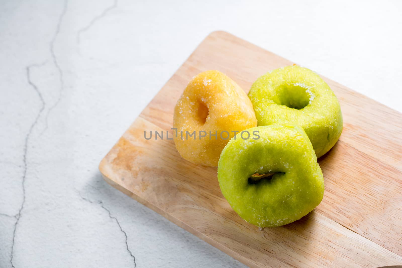 Vanilla and pandan doughnut on wooden chopping board. Breakfast concept.