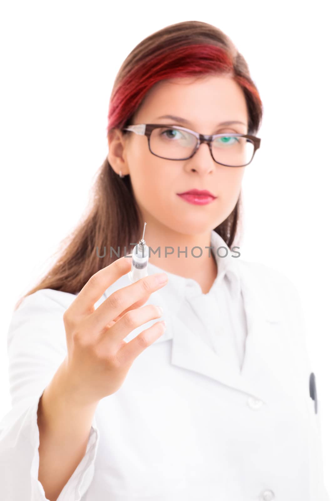 Close up of a young serious female doctor with glasses holding a syringe with needle, isolated on white background. Health care concept.
