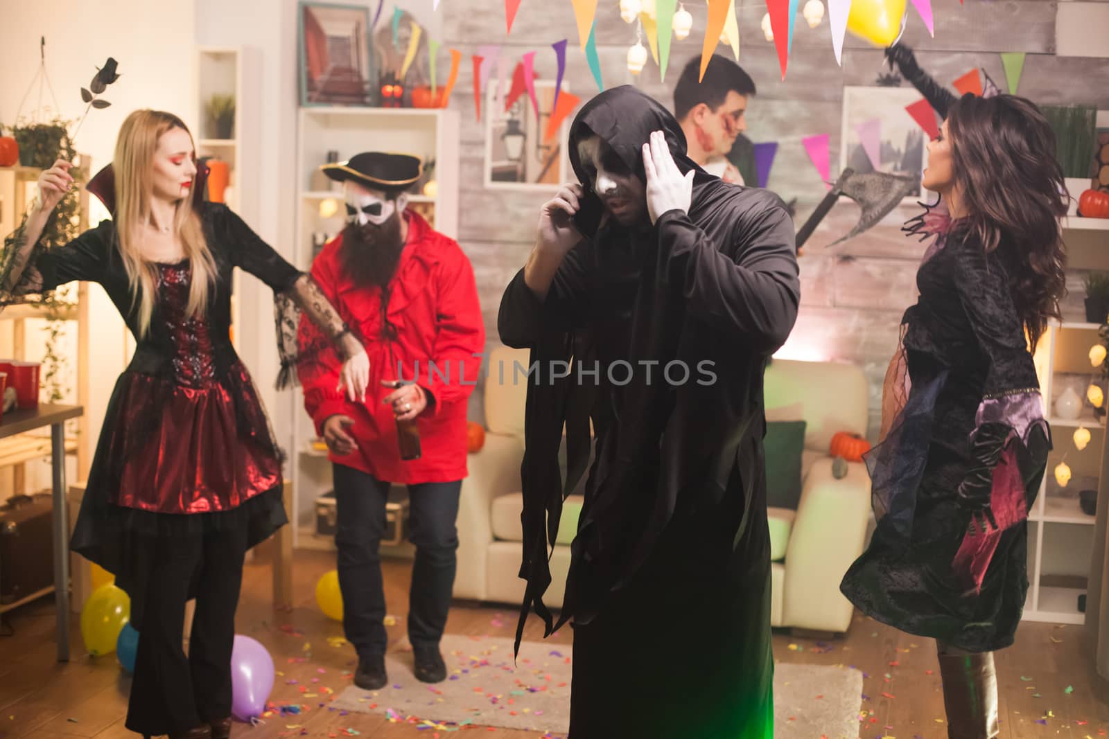 Grim reaper talking on the phone at halloween celebration by DCStudio