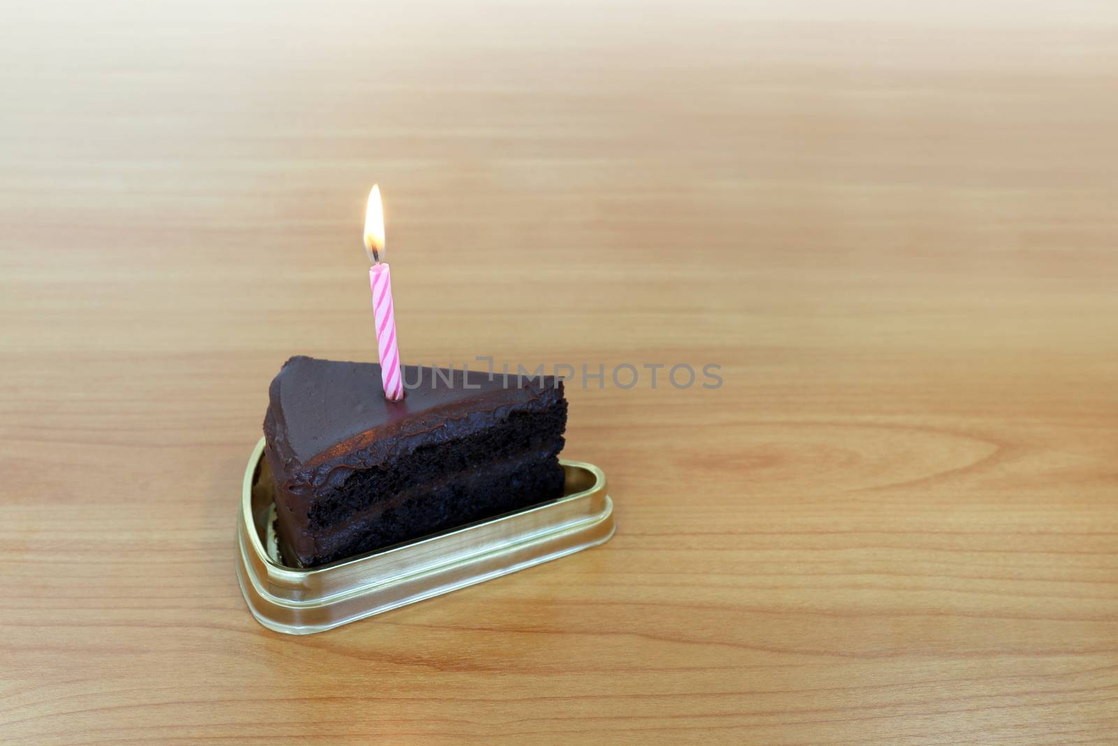 HBD cake Chocolate dark 1 piece crescent, Blowing Cake Candle brown, Happy Birthday one year anniversary on table wood